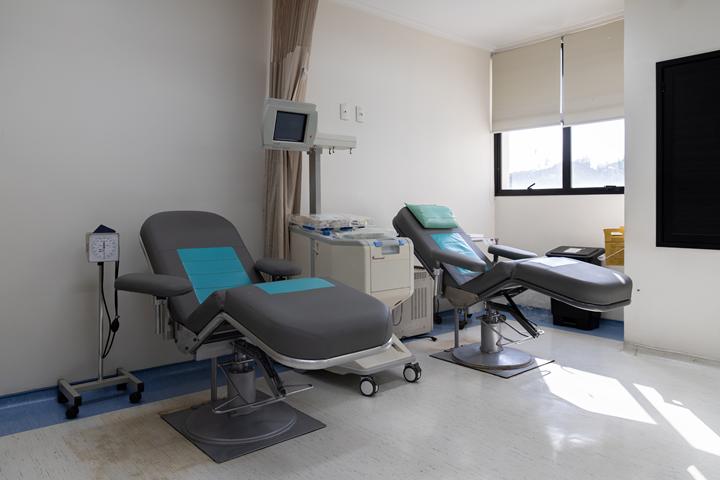 Sala limpa e iluminada com cadeiras reclináveis preparadas para receber doadores.