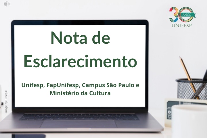 A imagem mostra um laptop sobre uma mesa, com a tela exibindo um comunicado oficial intitulado "Nota de Esclarecimento". O texto na tela menciona a Unifesp, FapUnifesp, Campus São Paulo e o Ministério da Cultura. No canto superior direito, há um logotipo comemorativo dos 30 anos da UNIFESP. Ao lado do laptop, há alguns itens sobre a mesa, incluindo um porta-lápis com canetas e um copo branco. No canto esquerdo da imagem, há um crédito à plataforma Freepik pela imagem de fundo.