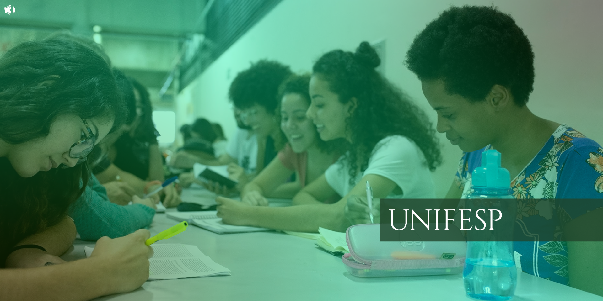 A imagem mostra um grupo de estudantes em um ambiente acadêmico, provavelmente uma sala de estudo ou biblioteca da UNIFESP. Eles estão sentados ao redor de uma mesa, escrevendo, lendo e interagindo entre si com expressões de concentração e entusiasmo. Há materiais como cadernos, livros, canetas e garrafas de água sobre a mesa. A sobreposição esverdeada e a palavra "UNIFESP" destacada no canto direito indicam que a imagem está relacionada à Universidade Federal de São Paulo.