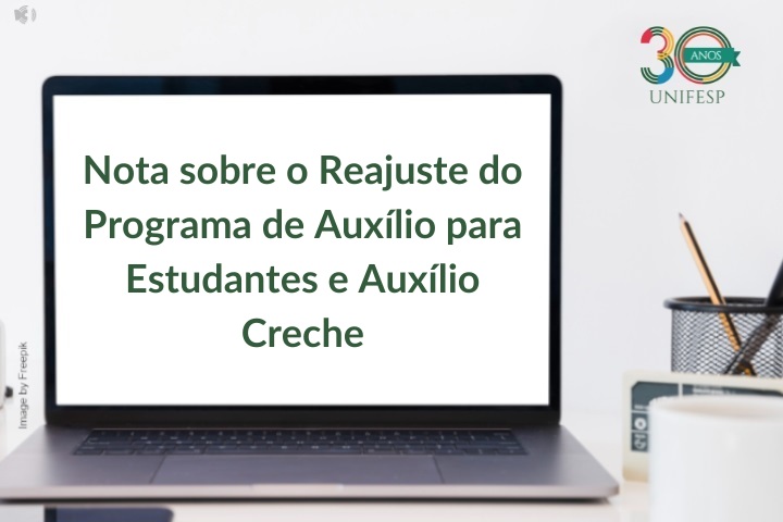 A imagem apresenta uma nota informativa da UNIFESP (Universidade Federal de São Paulo), com destaque para o tema:  "Nota sobre o Reajuste do Programa de Auxílio para Estudantes e Auxílio Creche"  O texto está exibido na tela de um notebook, com fundo claro e elementos de escritório ao redor (porta-lápis, caderno). No canto superior direito, aparece o logotipo de 30 anos da UNIFESP.  A imagem sugere uma comunicação institucional direcionada aos estudantes, informando sobre mudanças nos auxílios financeiros oferecidos pela universidade.