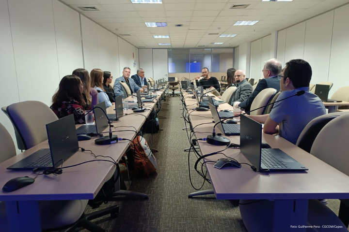 Imagem com pessoas sentadas em duas mesas durante reunião sobre o curso em Brasília