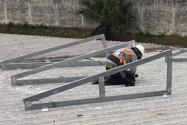 Painel da unisa sendo instalado por um funcionário da empresa responsável